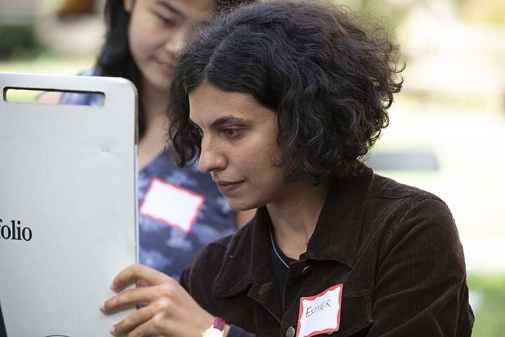 Close view of two women students with name tags working together at an easel
