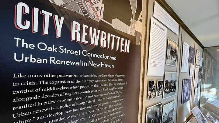 Wall of mounted display panels, title reads "City Rewritten, The Oak Street Connector and Urban Renewal in New Haven"