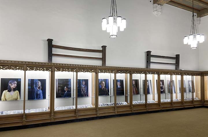 series of portraits lined up in a glass display 