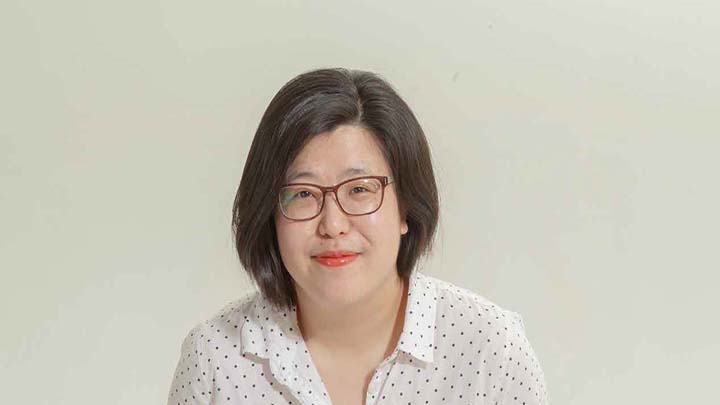 Asian American woman wearing glasses and white polka dot shirt