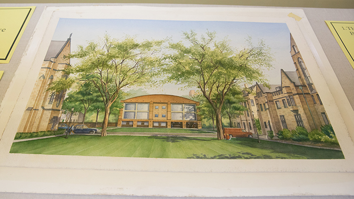 Colored rendering of a building set on a green field flanked by budding trees and with rows of brownstone buildings on either side.