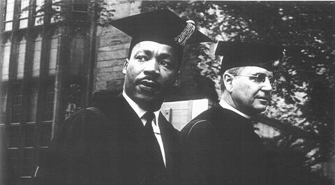 A black and white photo of Martin Luther King and President Kingman Brewster wearing cap and gown