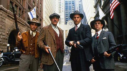 Actors from the cast of The Untouchables standing on a Chicago street in costume