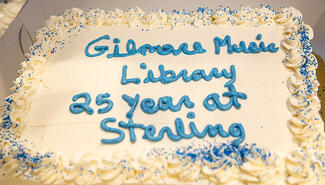 cake with white icing with "Gilmore Music Library 25 years at Sterling" written in blue icing