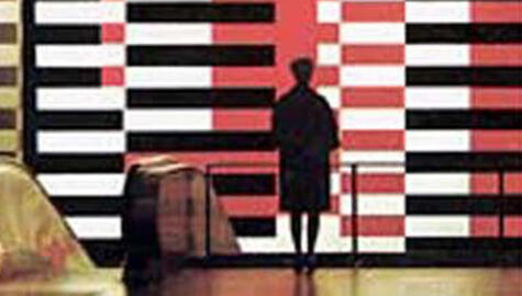 Silhouette of back of woman with knee-length coat standing in front of large mural painted with interlocking red, black, and white horizontal stripes