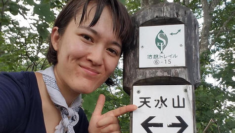 Photo of Yale student Sarah Adams pointing to a sign post on the Shinetsu Trail in Japan